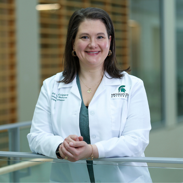 Allison Kuipers wearing a lab coat in the MSU research center.